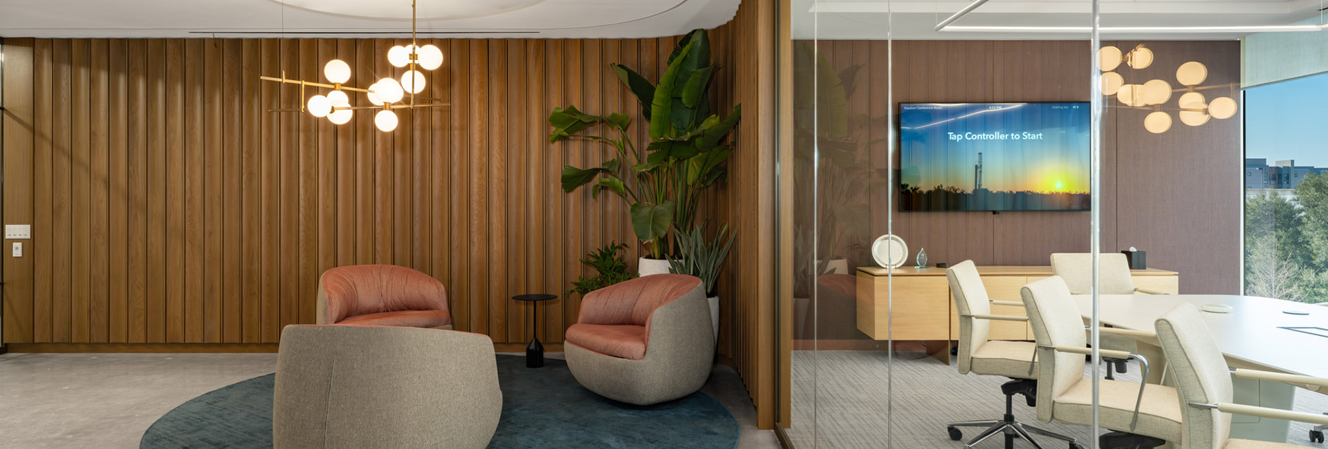 Kimmeridge Texas Gas image of a waiting area with modern couches and the conference room with wall of windows built by Structure Tone Southwest