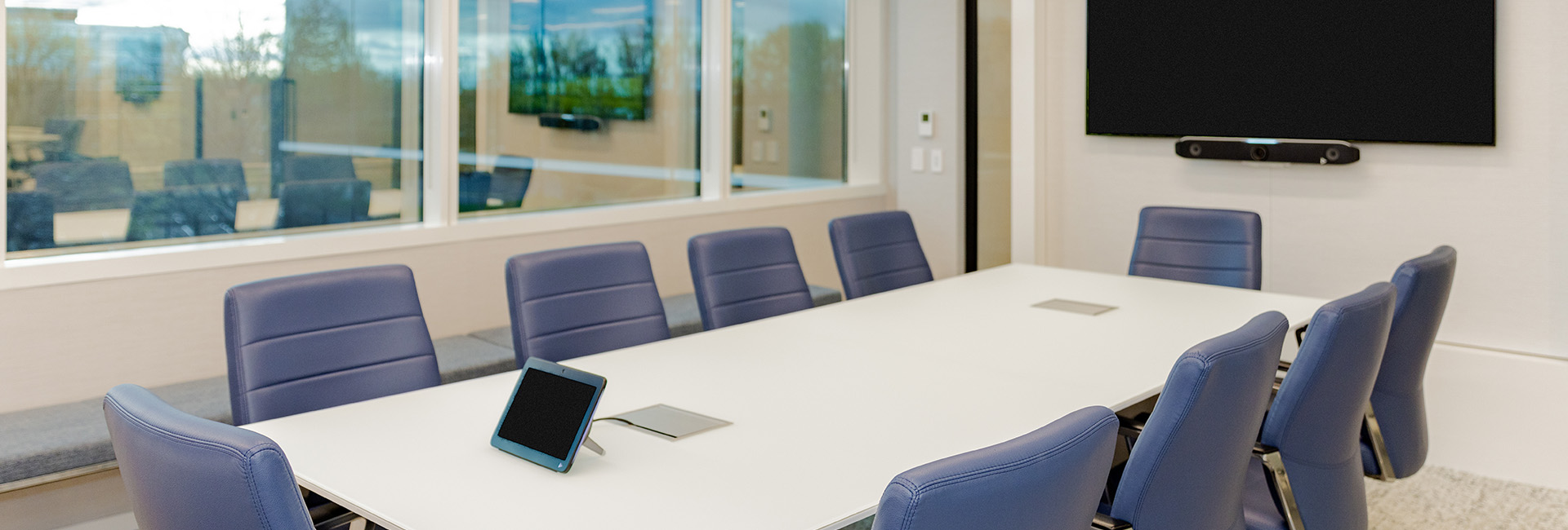 3000 Atrium Way conference room with white table and blue chairs