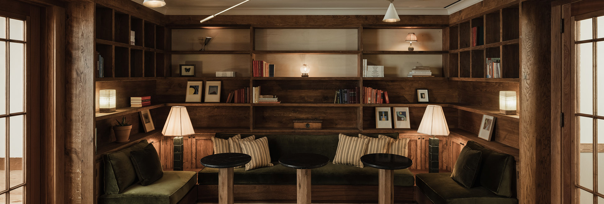 Marshall Wace reading nook with velvet bench seating and book shelf cubby with warm lighting built by Structure Tone New York