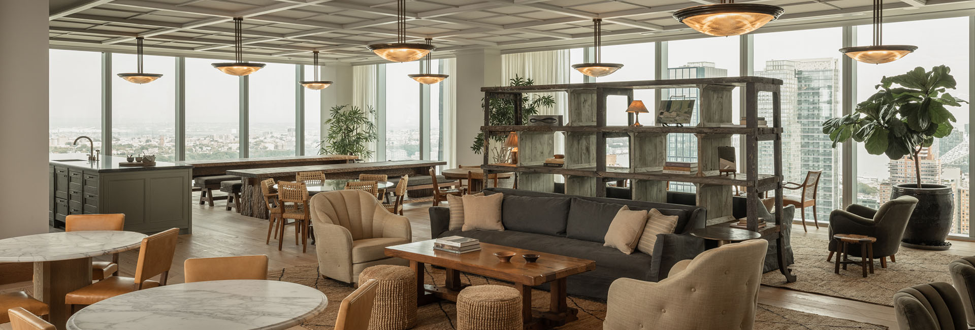 Marshall Wace lounge area with couches, tables, book shelf and wall of windows built by Structure Tone New York