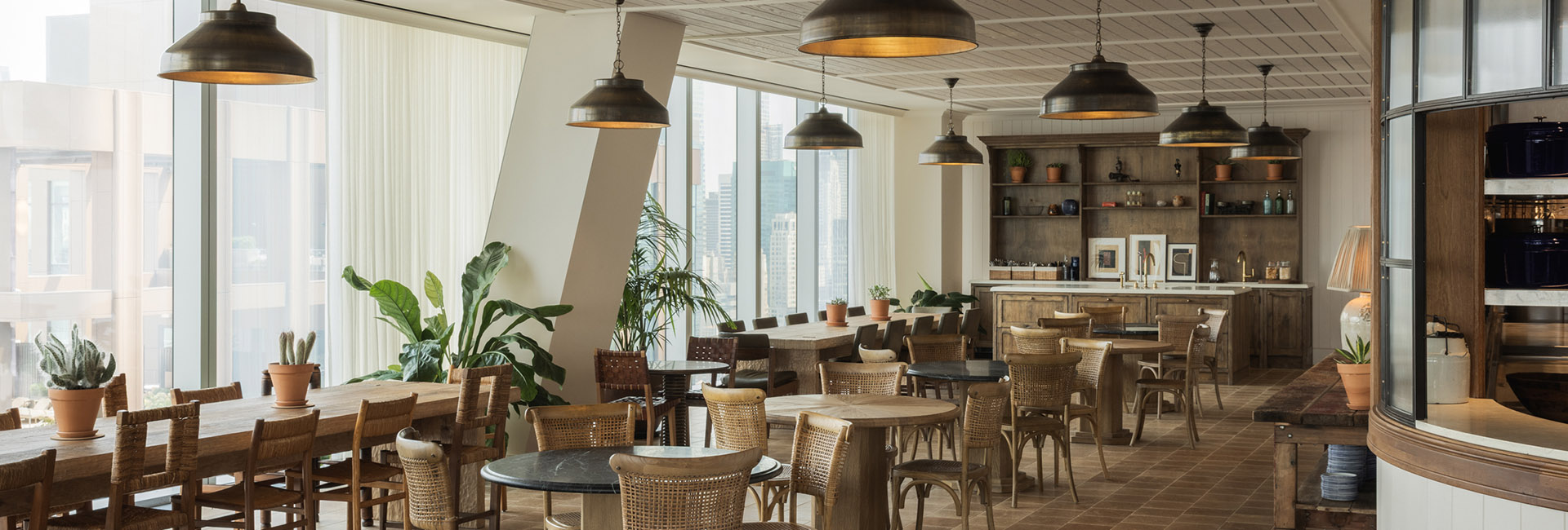 Marshall Wace break area with wood tables and chairs many terra cotta potted plants warm feel built by Structure Tone NY