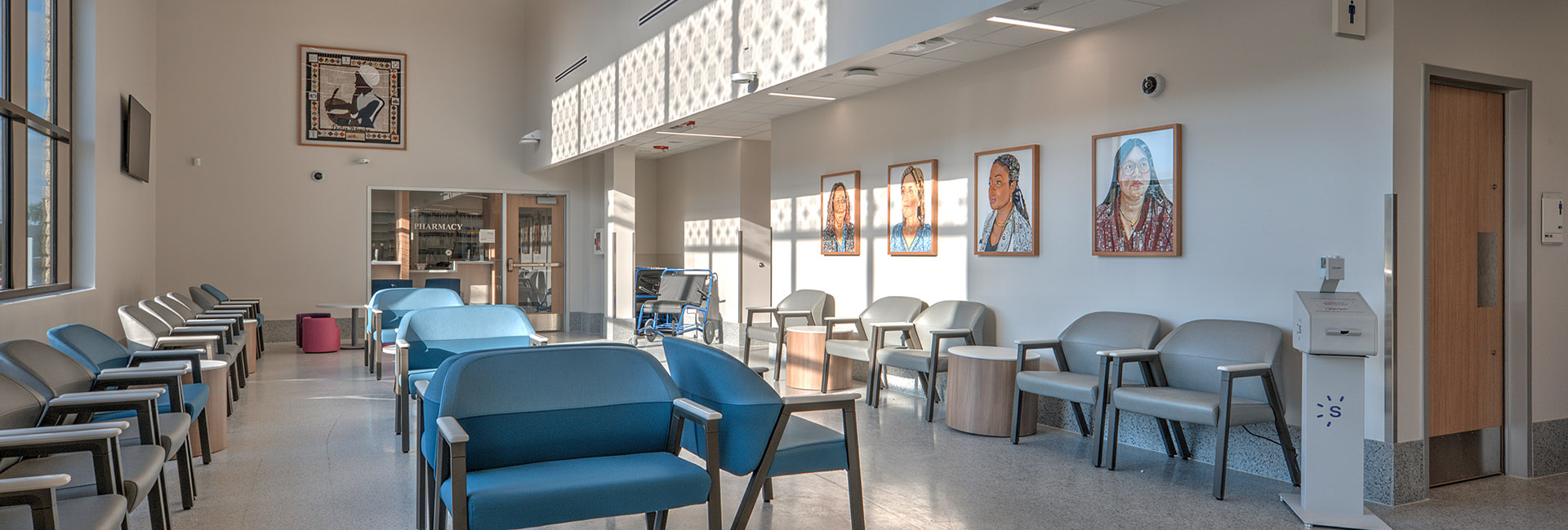 University Health Wheatley image of lobby with paintings on walls and blue and grey chairs