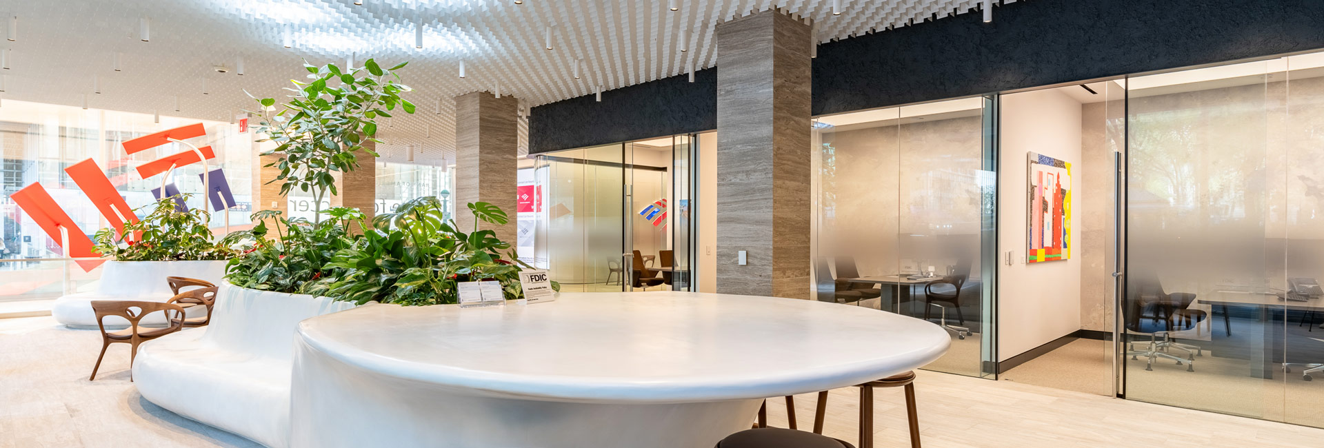 A spacious area featuring a large table surrounded by several chairs.