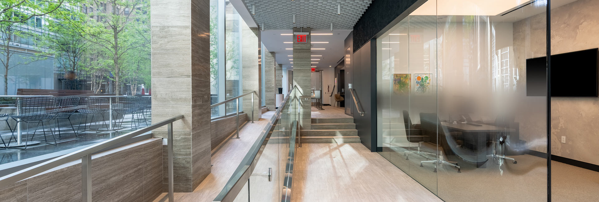 A bright hallway with glass walls and a large window, creating an open and airy atmosphere.