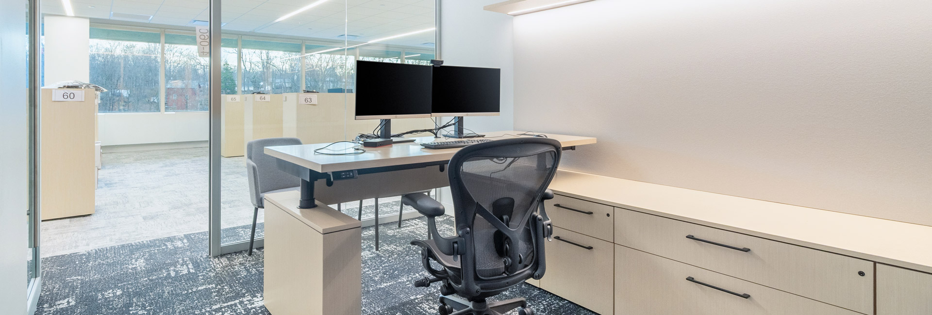 Inside of an office space with a computer and desk space.