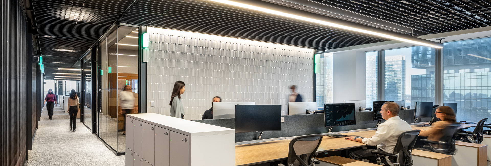An office scene featuring several people focused on their work at individual desks.