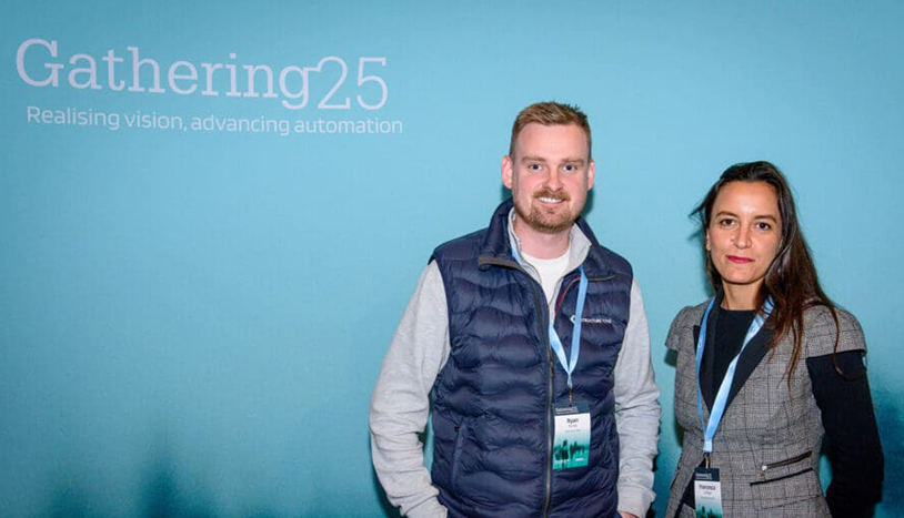 UK CitA two people at a gathering in front of a banner