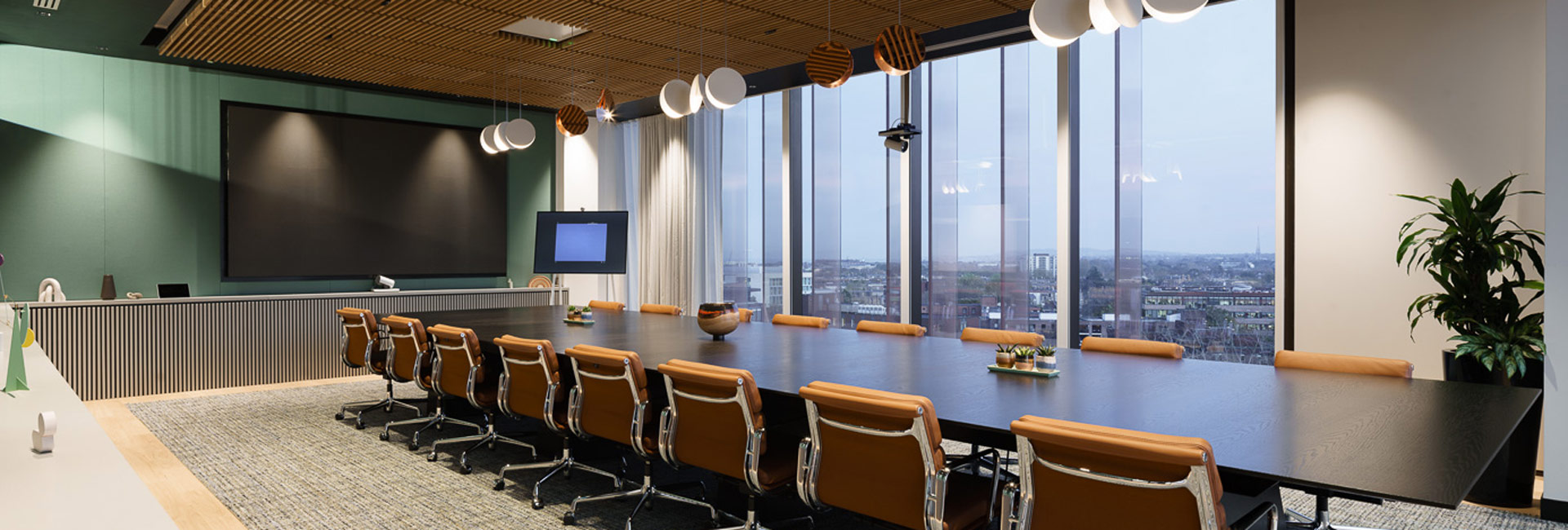 A large conference room table with several chairs seated around.