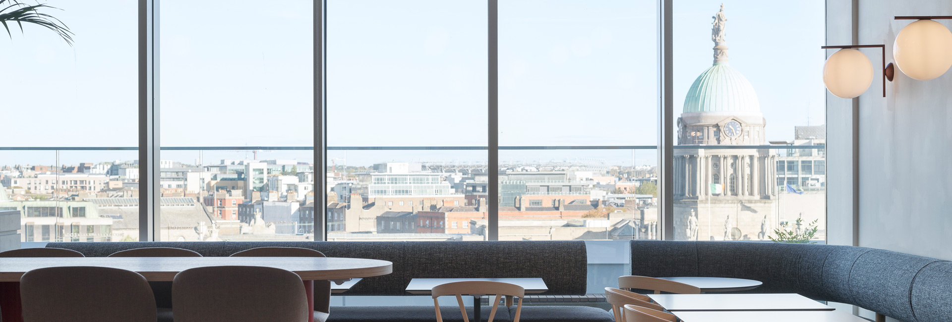 Several tables and chairs with windows overlooking the city