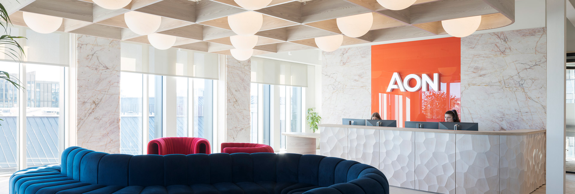 A receptionist sitting at her desk with couches for clients to sit.