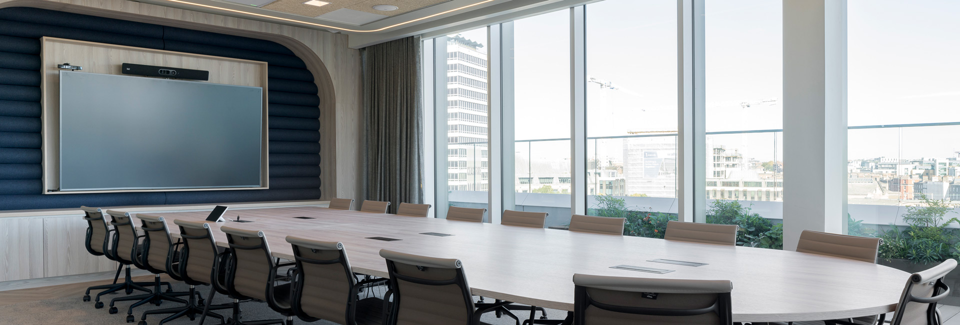 A large conference room with a long table and several chairs