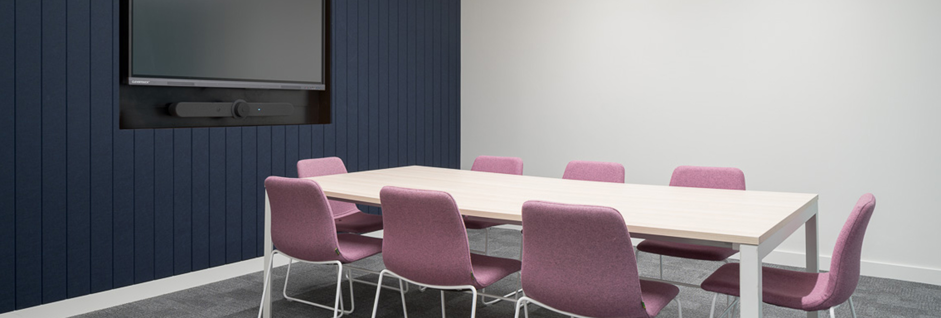 A conference room with a long table and chairs.