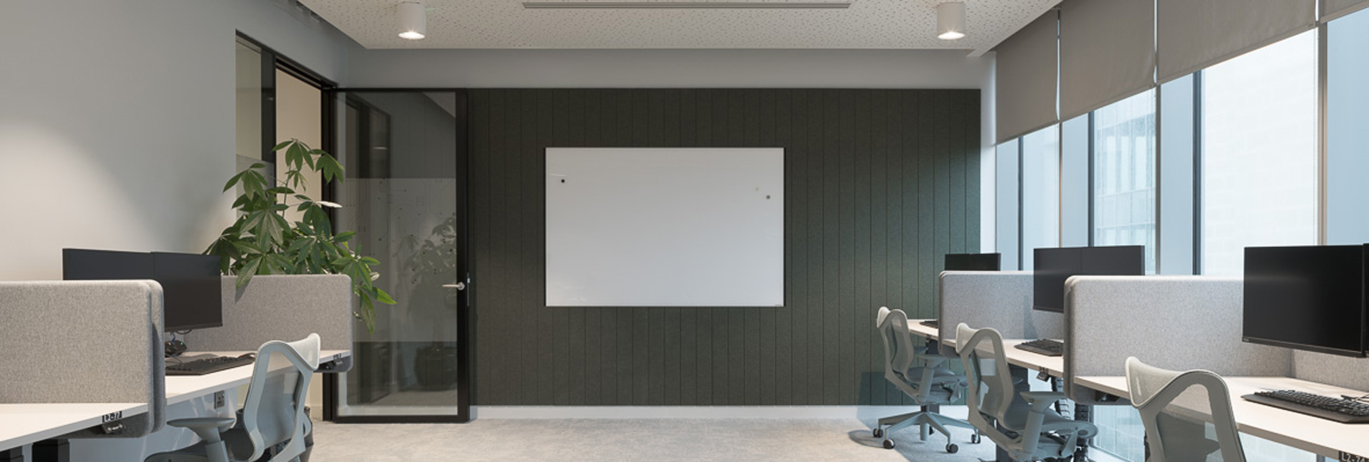 A meeting room with a projector and several computers for training