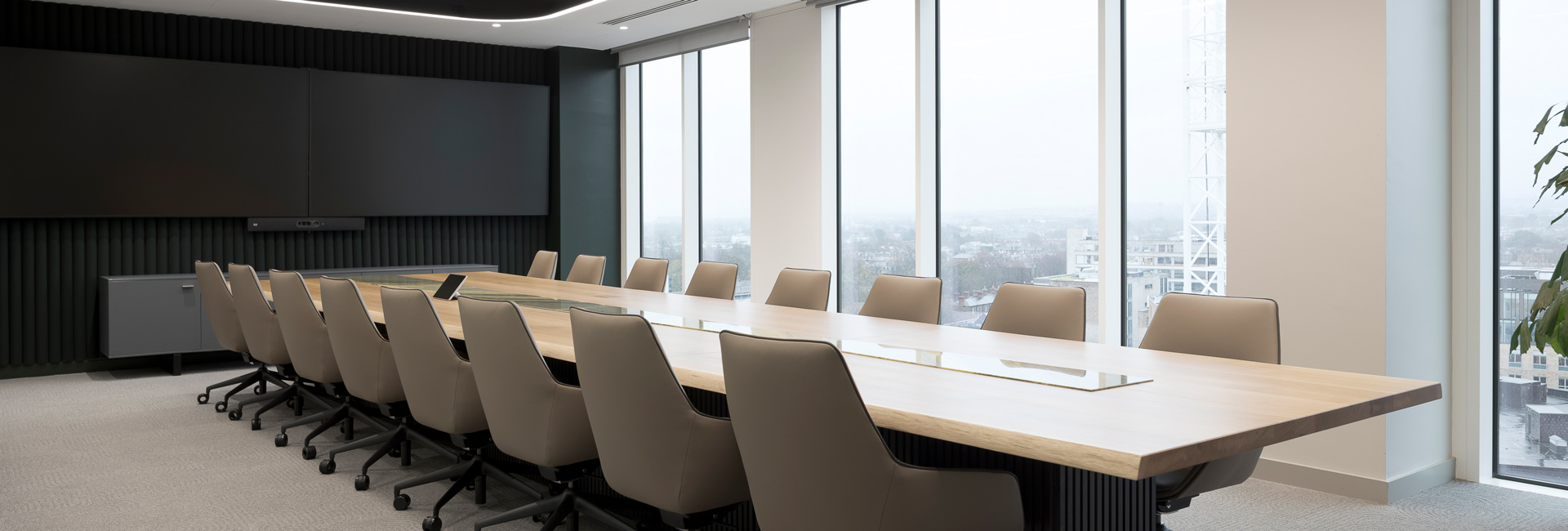 A large conference room with a long table and several chairs