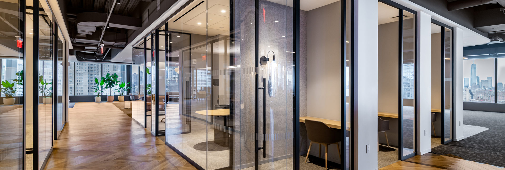 A row of meeting rooms with full length glass walls.