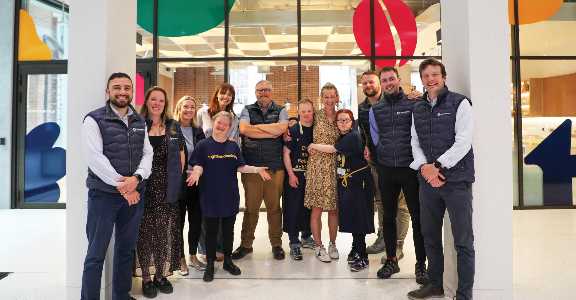 A group of people standing outside the Together Academy.