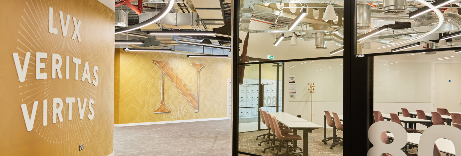 Hallway of Northeastern University with yellow walls and glass doors.