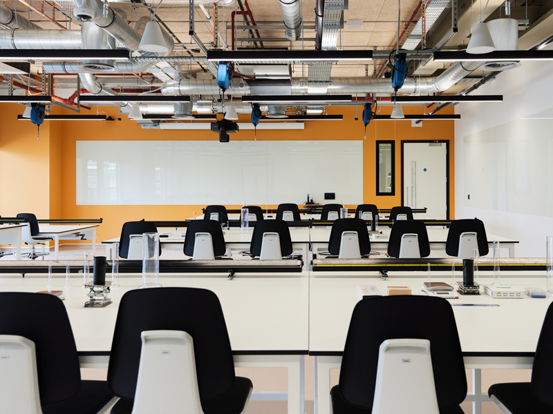 A classroom with several tables and chairs