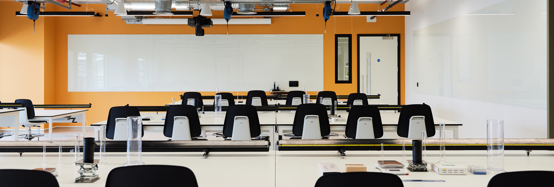 A classroom with several tables and chairs