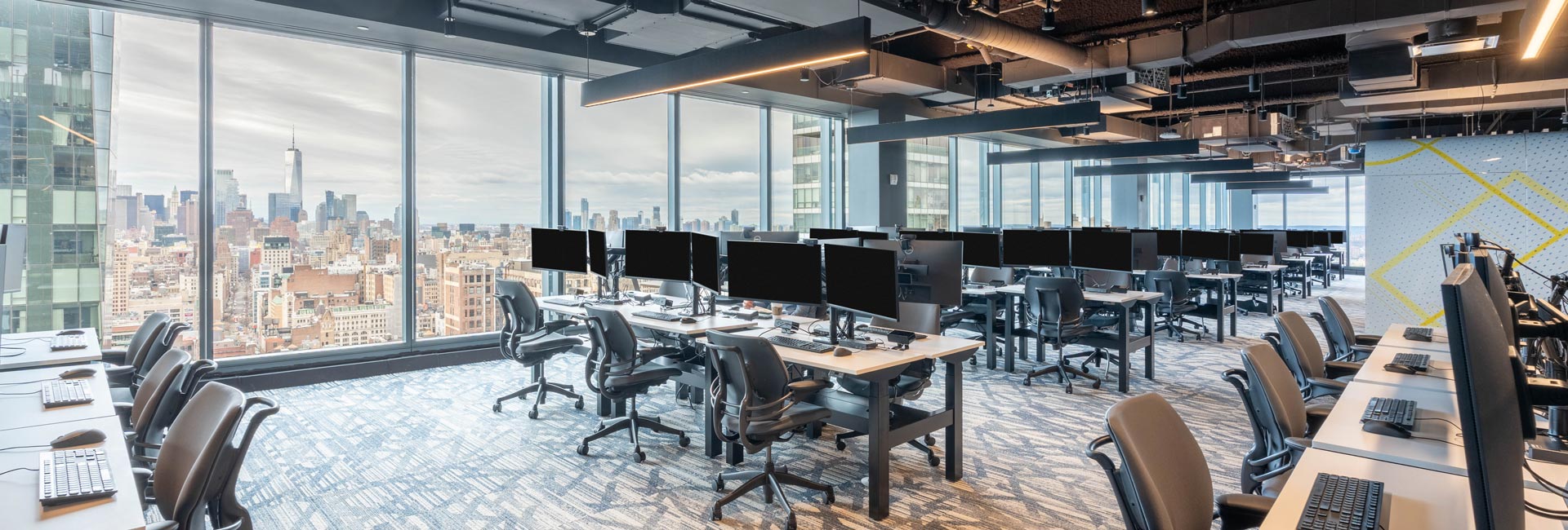 A large open office area with several desks and chairs