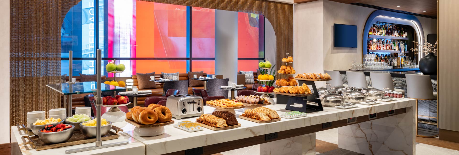Breakfast buffet with fruit, pastries, breads, and hot dishes beside the hotel’s Bowtie Bar.