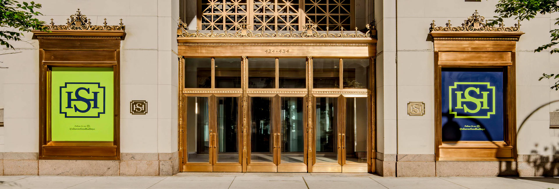 Ornate brass-framed entrance to Shaver Hall, flanked by digital displays featuring the venue’s logo.