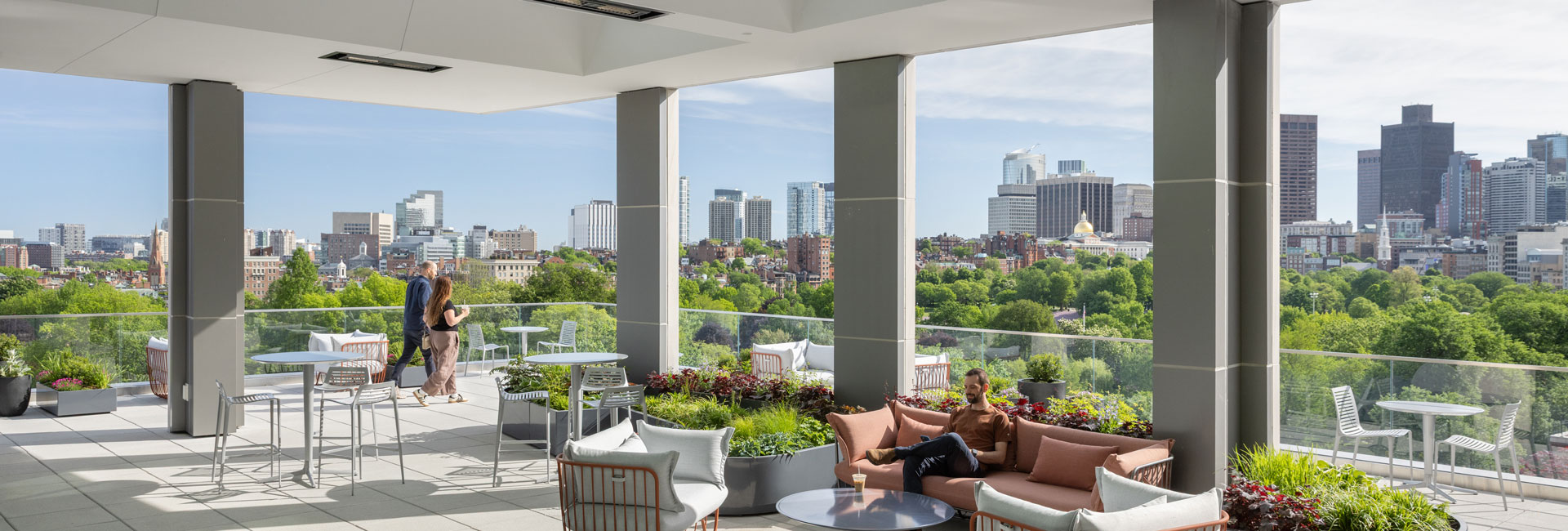 Landscaped rooftop terrace with lounge seating and panoramic views of Boston Common, the State House, and the city skyline.