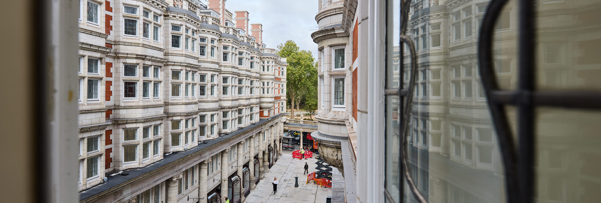 View from a window overlooking the historic stone-and-brick buildings and pedestrian walkway of Sicilian Avenue.