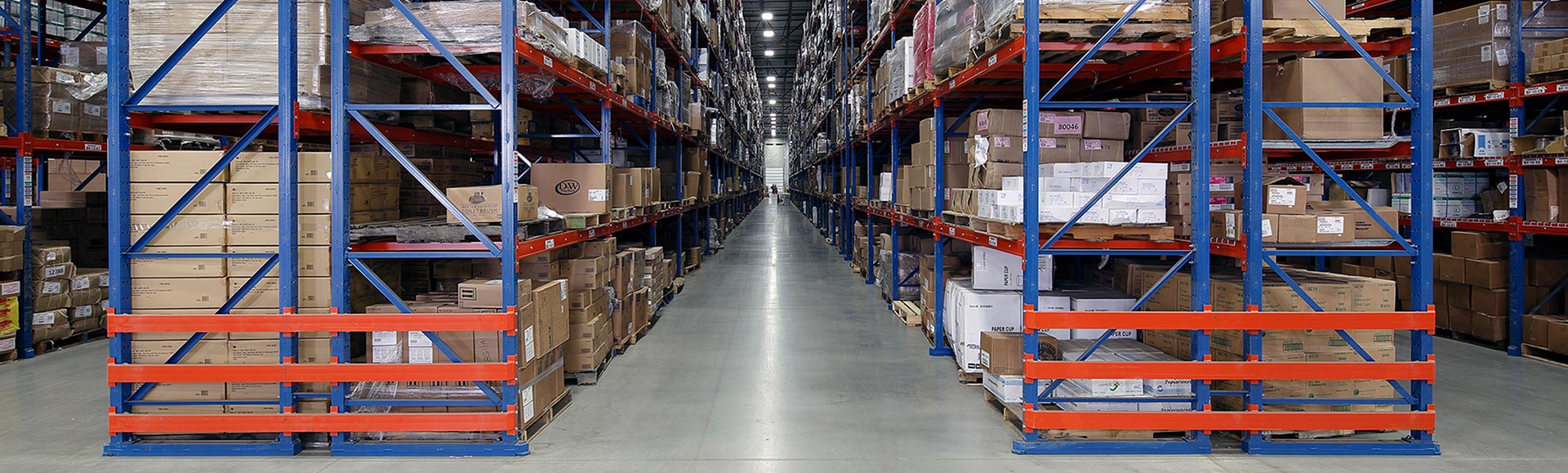 A spacious warehouse filled with numerous shelves and boxes, providing ample storage capacity.